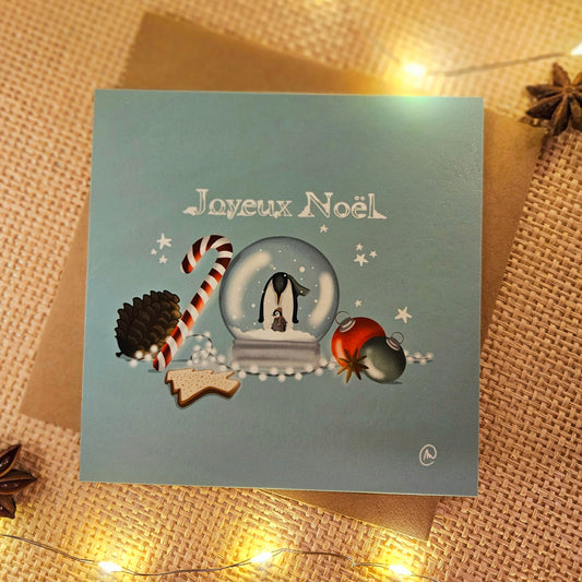 Carte de Noël représentant une maman pingouin et son petit dans une boule à neige