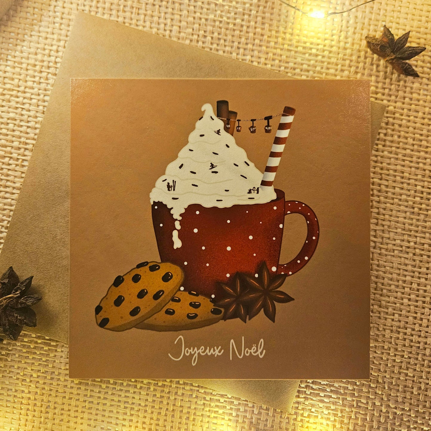 Carte de Noël représentant un chocolat chaud enneigé surmonté d’une chantilly saupoudré de skieurs