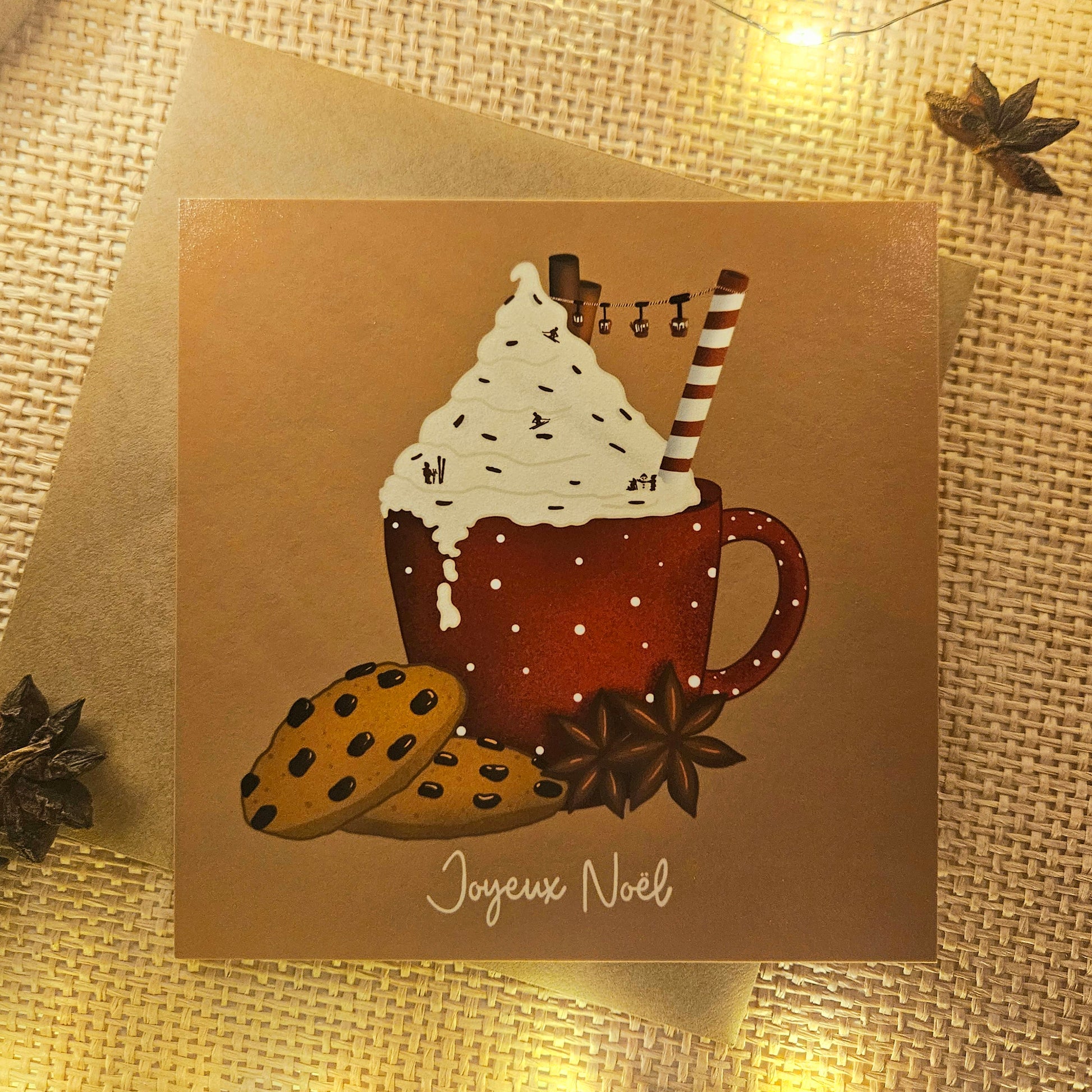 Carte de Noël représentant un chocolat chaud enneigé surmonté d’une chantilly saupoudré de skieurs