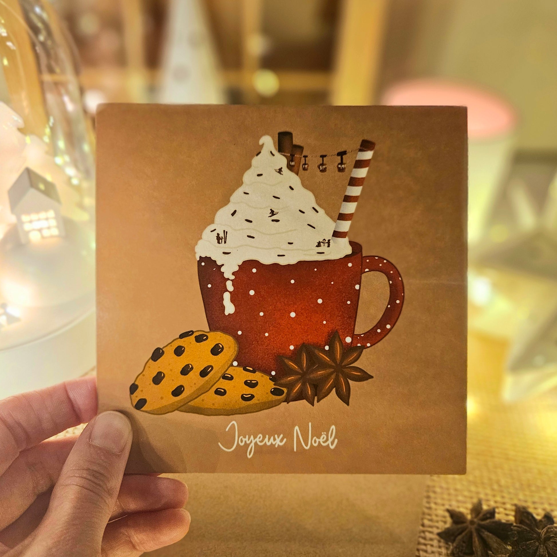 Carte de Noël représentant un chocolat chaud surmonté d’une chantilly saupoudré de skieurs